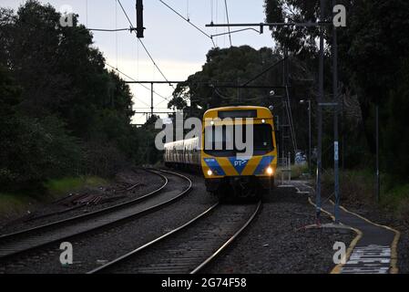 Un treno Comeng, parte della flotta di Melbourne dei treni della Metropolitana, fa un giro di curva sulla sua strada per Sandringham in una giornata grigia Foto Stock