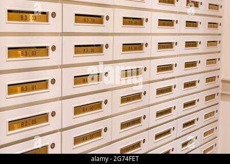 File di caselle postali nella sala postale dell'edificio condominiale Foto Stock