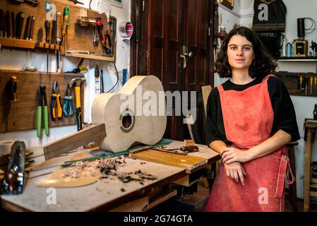 donna liutaio che fa chitarre nel suo laboratorio di strumenti musicali Foto Stock