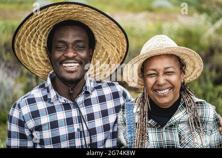 Gli agricoltori afro-americani sorridono sulla macchina fotografica durante il periodo di raccolta - Focus on Faces Foto Stock