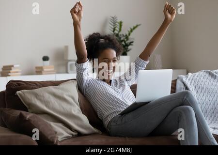 La donna afro-americana ha festeggiato il successo guardando lo schermo del portatile Foto Stock