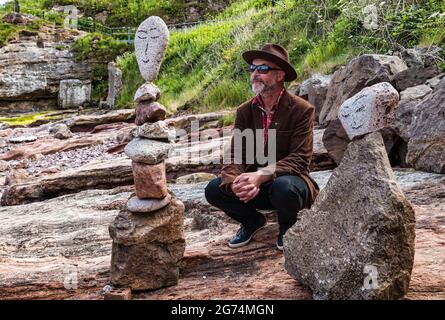 James Craig Page, organizzatore del Campionato europeo di Stacking della pietra con sculture di roccia sulla spiaggia Eye Cave, Dunbar, East Lothian, Scozia, Regno Unito Foto Stock