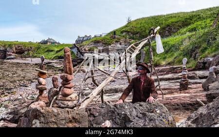 James Craig Page, organizzatore del Campionato europeo di Stacking della pietra con sculture di roccia sulla spiaggia Eye Cave, Dunbar, East Lothian, Scozia, Regno Unito Foto Stock