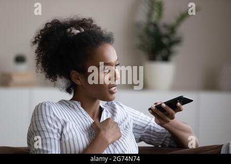 Primo piano messaggio audio di registrazione afroamericano sorridente sullo smartphone Foto Stock