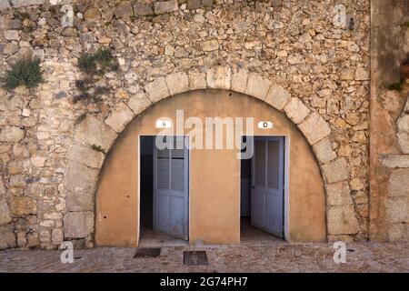 Bagni pubblici francesi o WC pubblico costruito sotto il vecchio arco di pietra Foto Stock