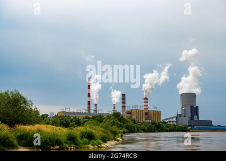 Panorama con una centrale a carbone a Kozienice. Pile di fumo e vapore dalle torri di raffreddamento. Foto scattata in una giornata nuvolosa con luce naturale Foto Stock