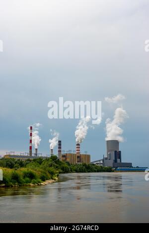 Panorama con una centrale a carbone a Kozienice. Pile di fumo e vapore dalle torri di raffreddamento. Foto scattata in una giornata nuvolosa con luce naturale Foto Stock
