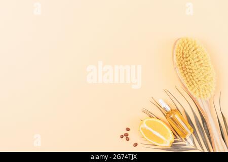 Set spazzolatura a secco con spazzola da massaggio in fibre di cactus e olio anticellulite per pelle con caffeina ed estratto di arancia su fondo beige con co Foto Stock