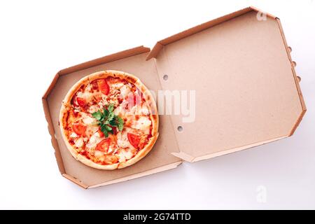 Gustosa pizza nella scatola di consegna su sfondo bianco Foto Stock