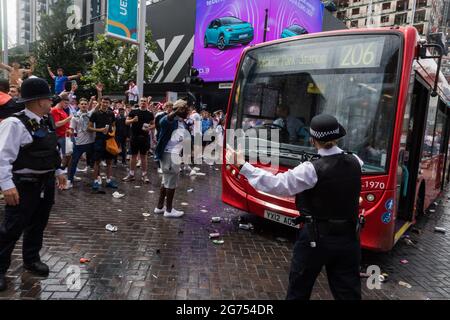 Wembley Park, Regno Unito. 11 Luglio 2021. Migliaia di tifosi inglesi si stanno recando a Wembley questa mattina per immergersi nell'atmosfera prima della partita storica di questa sera. I fan della Olympic Way sono andati selvaggi, sbattendo in cima a un autobus e pelandolo con bottiglie e lattine di birra. La polizia ha dovuto intervenire per far passare il conducente. Lo stadio di Wembley ospiterà questa sera la finale Euro 2020 tra Italia e Inghilterra. È la prima grande finale in cui l'Inghilterra avrà giocato dopo aver vinto la Coppa del mondo nel 1966. Credit: amanda Rose/Alamy Live News Foto Stock