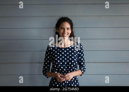 Ritratto di felice bella donna millennial latino 30s che indossa un abito Foto Stock