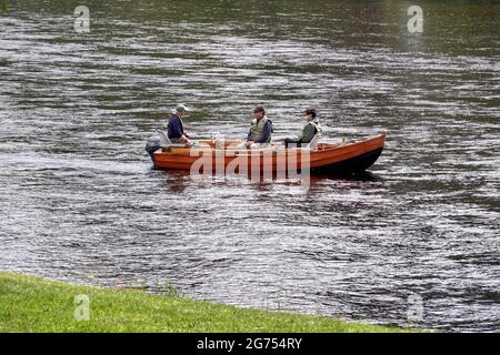 Tre uomini in una barca di legno, che pescano sul fiume Tay, Dunkeld, Scozia Foto Stock