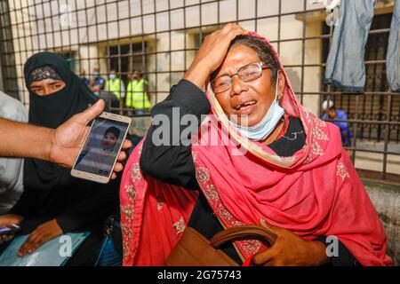 I parenti delle vittime si riuniscono al Dhaka Medical College Hospital come medici ufficiali raccogliere campioni di sangue dai parenti delle vittime di t Foto Stock