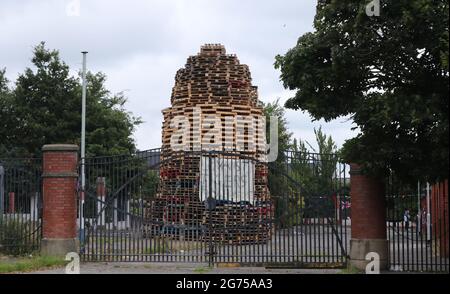 Un controverso falò è costruito accanto a un muro di pace tra la Loyalist Tigers Bay e la zona nazionalista Newlodge di Belfast per inaugurare le dodici commemorazioni. Data immagine: Sabato 10 luglio 2021. Foto Stock