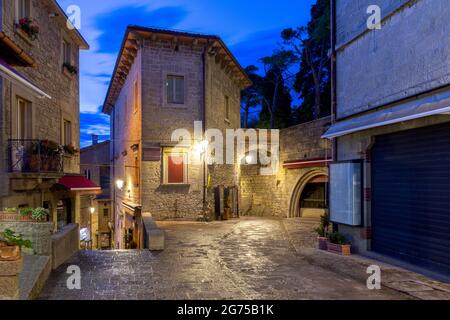 Vecchia strada medievale stretta in illuminazione notturna. San Marino. Italia. Foto Stock