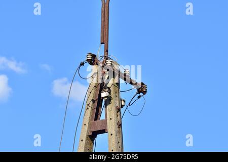 Cavi elettrici rotti sul palo e sulla lampada. Estate. Foto Stock