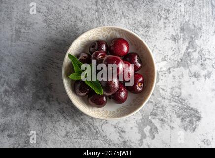 Piccole ciotole piene di ciliegie poste su sfondo bianco. Sensazione di freschezza e frutta succosa. Foto Stock