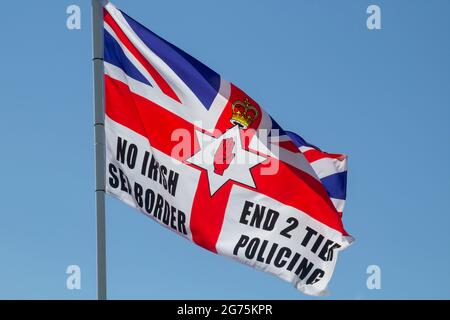 11 luglio 2021 una bandiera dell'Unione con slogan politici che volano accanto al falò annuale nella proprietà di Kilcooley nella contea di Bangor in Irlanda del Nord Foto Stock