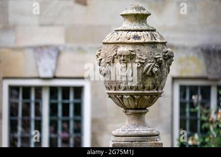 Primo piano di un vaso in pietra intagliato ornato o di un'urna montata sulla base a West Walk, Salisbury, Wiltshire, Regno Unito, il 11 luglio 2021 Foto Stock