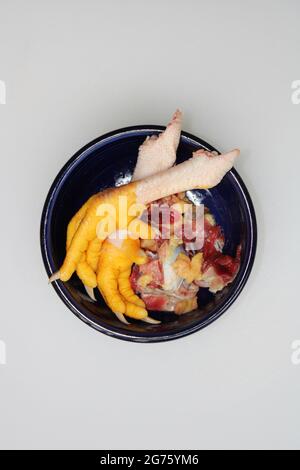 Scarti di butchering di pollo in un Blue Bowl Foto Stock