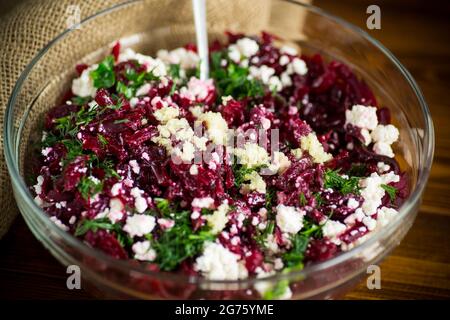 insalata dietetica di barbabietole bollite con noci e formaggio di cottage su un tavolo di legno Foto Stock