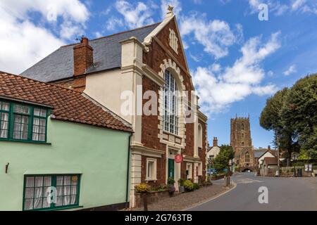 Chapel House a Dunster West Street, Somerset, con la Chiesa Priorato di San Giorgio sullo sfondo. Foto Stock