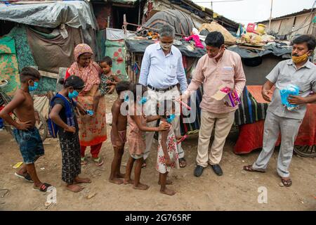 Nuova Delhi, India. 11 Luglio 2021. I volontari del Bhartiya Janta party distribuiscono cioccolatini e facemask ai bambini di baraccopoli a New Usmanpur durante la campagna di sensibilizzazione Covid-19. Hanno anche informato i bambini circa le misure di Covid-19. Le autorità governative e sanitarie prevedono che i bambini saranno maggiormente colpiti dalla terza ondata in India. Credit: SOPA Images Limited/Alamy Live News Foto Stock