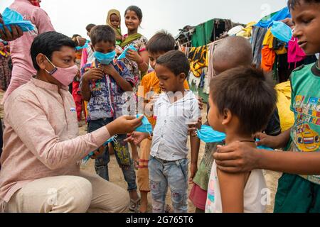 Nuova Delhi, India. 11 Luglio 2021. Bhuvnesh Singhal distribuisce maschere facciali ai bambini di slum a New Usmanpur durante la campagna di sensibilizzazione Covid-19. Hanno anche informato i bambini circa le misure di Covid-19. Le autorità governative e sanitarie prevedono che i bambini saranno maggiormente colpiti dalla terza ondata in India. Credit: SOPA Images Limited/Alamy Live News Foto Stock