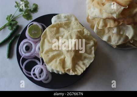 Un papadum anche chiamato papad è un piatto sottile, croccante, rotondo dall'India. Viene fatto friggendo o cucinando a caldo asciutto capovolgendolo sopra un'op Foto Stock