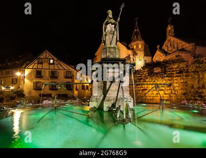 Eguisheim di notte: Statua di Papa Leone IX. (1002-1054) nella piazza del castello nella sua città natale, il villaggio dei viticoltori di Eguisheim nella regione Alsazia. Foto Stock