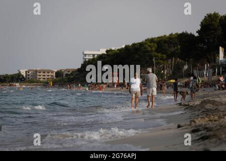 Spagna. 11 Luglio 2021. Si gode il mare sulla spiaggia Playa de Muro, nel nord di Maiorca. Il governo federale ha dichiarato tutta la Spagna con Maiorca e le isole Canarie in vista del rapido aumento del numero di Corona nell'area a rischio. Gli effetti pratici per i vacanzieri di Maiorca sono limitati per il momento. Credit: Clara Margais/dpa/Alamy Live News Foto Stock