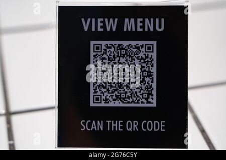 Visualizzare il menu e eseguire la scansione del simbolo del codice QR sul tavolo del bar Foto Stock