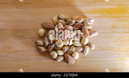 Frutta secca su fondo di legno, frutta secca e frutta, fuoco selettivo Foto Stock