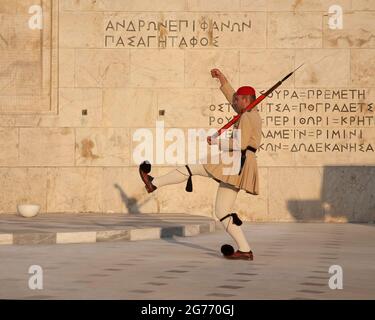 Cambio della guardia presidenziale ad Atene accanto al muro del Parlamento greco con le citazioni di Tucidide dall'Orazione funeraria di Pericle Foto Stock
