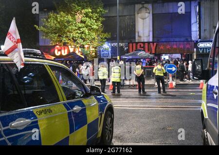 Broad Street, Birmingham 11 luglio 2021 i tifosi si sono scontrati l'uno con l'altro dopo che l'Inghilterra si è schiantata fuori dalla finale Euro 2020 con l'Italia che ha vinto a pene, rendendolo 56 anni di ferimento. I fan si sono rovesciati fuori dei pub e dei bar su Broad Street nel centro di Birmingham, mentre la polizia ha formato linee. Molti fan sembravano infeludati, una donna sembrava perduta mentre camminava attraverso le fontane. Una granata di fumo è stata lanciata anche mentre la polizia ha cercato di calmare i sostenitori, anche se un kit inglese con un ventilatore ha fatto sventolare una bottiglia di vodka in aria prima che la polizia minacciasse di usare il gas se non lo ha fatto cadere. L'uomo è stato poi arrestato. Foto Stock