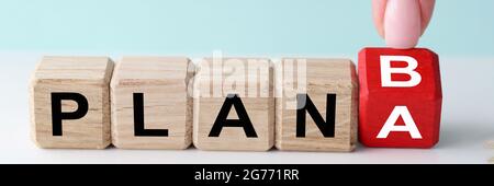 Femmina finger flipping cubo di legno con piano a e b segnali Foto Stock