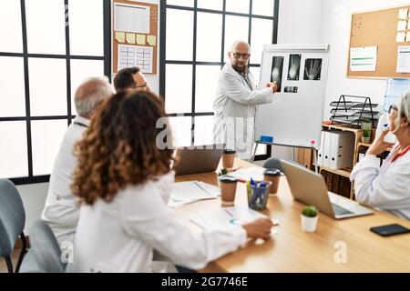 Gruppo di dottori di mezza età che discute in una riunione medica presso l'ufficio della clinica. Foto Stock