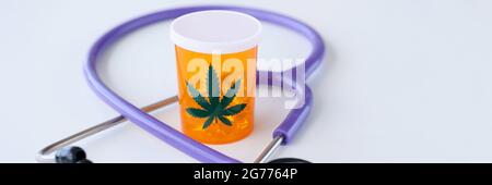 Vaso di pillole di marijuana in piedi vicino stetoscopio closeup Foto Stock