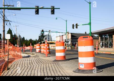 Garofano, WA, USA - 11 luglio 2021; barili da costruzione e recinzione di sicurezza arancione nel centro di Carnation come parte di un miglioramento delle infrastrutture Foto Stock