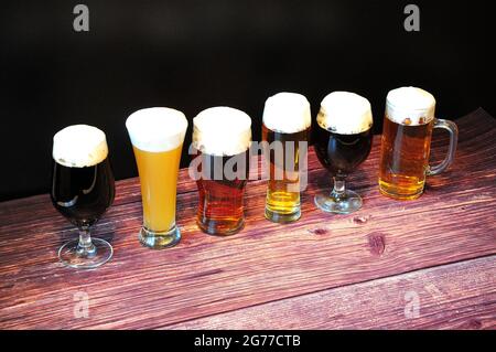 Tre diversi bicchieri da birra, con diversi tipi di birra, sono in fila. Primo piano. Foto Stock