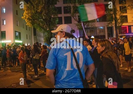 Fan trägt ein SSC Neapel Trikot mit der 10 von Diego Maradona. Tausende Fußball tifosi feierten am 12. Juli 2021 in München den Sieg der Italienischen Nationalmannschaft bei der Europameisterschaft 2020 über Inghilterra. Die situation blieb durchgehend friedlich und viele Nicht-Italiener*innen beteiligten an den Feiern. * ventilatore che indossa la maglia n. di Napoli di Diego Armando Maradona. Migliaia di tifosi hanno festeggiato il 12 luglio 2021 nella Leopoldstrasse di Monaco, Germania, dopo che l'Italia ha vinto l'Euro 2020 contro l'Inghilterra. Molti non italiani si sono Uniti alla celebrazione mentre la polizia ha monitorato il situ Foto Stock