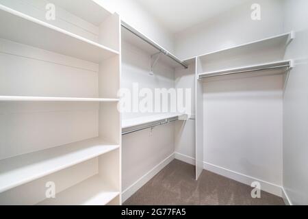 Piccola passeggiata in armadio con scaffalature bianche e canne Foto Stock