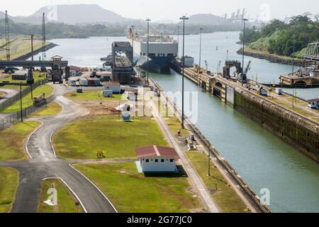 Un grande carico passò appena attraverso il canale di Panama in una giornata di sole. Si possono vedere gli uffici principali e una delle serrature. Foto Stock