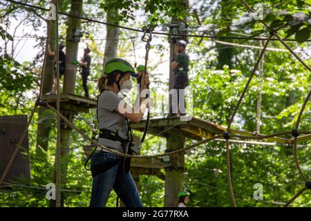 Eccessiva cautela, regolamentazione o abitudine? Donna con maschera FFP2 su un corso di arrampicata Foto Stock