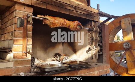 Spit agnelli arrosto, tradizionale modo di tostare agnelli su una sputa di rotisserie in Bulgaria. Cucinando e arrostendo l'agnello intero ha chiamato cheverme ad un ristoratore Foto Stock