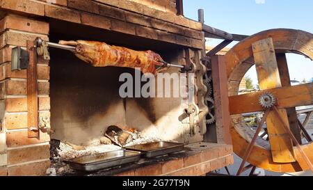 Spit agnelli arrosto, tradizionale modo di tostare agnelli su una sputa di rotisserie in Bulgaria. Cucinando e arrostendo l'agnello intero ha chiamato cheverme ad un ristoratore Foto Stock