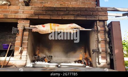 Spit agnelli arrosto, tradizionale modo di tostare agnelli su una sputa di rotisserie in Bulgaria. Cucinando e arrostendo l'agnello intero ha chiamato cheverme ad un ristoratore Foto Stock