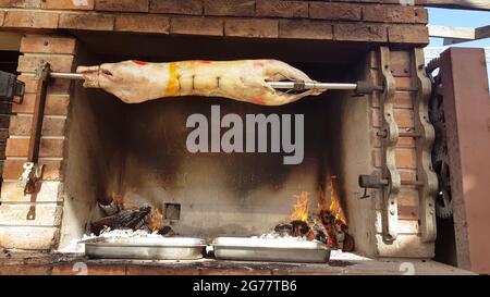 Spit agnelli arrosto, tradizionale modo di tostare agnelli su una sputa di rotisserie in Bulgaria. Cucinando e arrostendo l'agnello intero ha chiamato cheverme ad un ristoratore Foto Stock