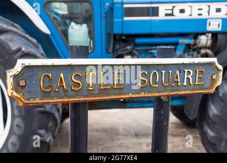 Cartello Castle Square di fronte a un vecchio trattore Ford, Tenby, Pembrokeshire, Galles Foto Stock