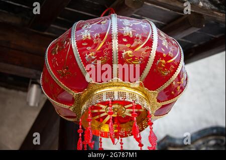 Jiangsu: Lanterna cinese decorativa appesa ad un vecchio edificio. Queste lanterne rosse sono ampiamente viste in tutta la Cina, spesso festeggiando i festival Foto Stock